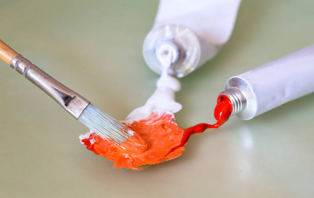 Mixing red and white oil paint with a paintbrush