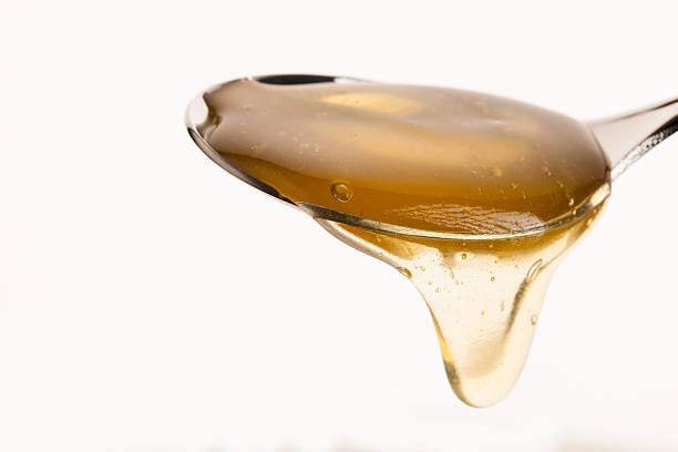 istock Spoon filled with sweet golden honey isolated over white background 509054568