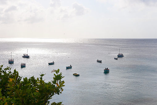 Fishing boats in a bay at the island of Curacao at sunset.