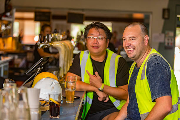 Workmen Relaxing With Beer After Work in High Visibility Clothes