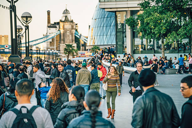 London, UK - September 6, 2015: Crowd of people walking along the bankside district of the Thames, Tower Bridge in the background.