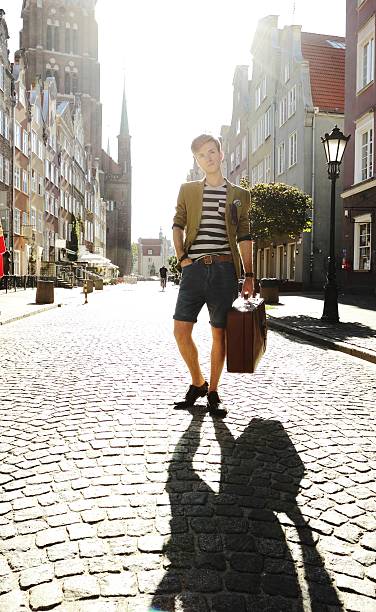 istock Young handsome man with suitcase on street 509075507