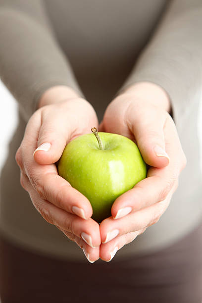 istock Woman holding a green apple 509075651