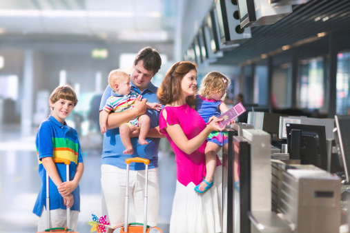 Big happy family with three kids travelling by airplane at Dusseldorf International airport, parents with teenager boy, toddler girl and little baby holding colorful luggage for summer beach vacation