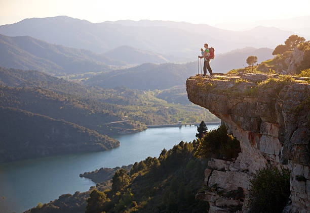 istock Hiker with baby standing on cliff and enjoying valley view 509076679