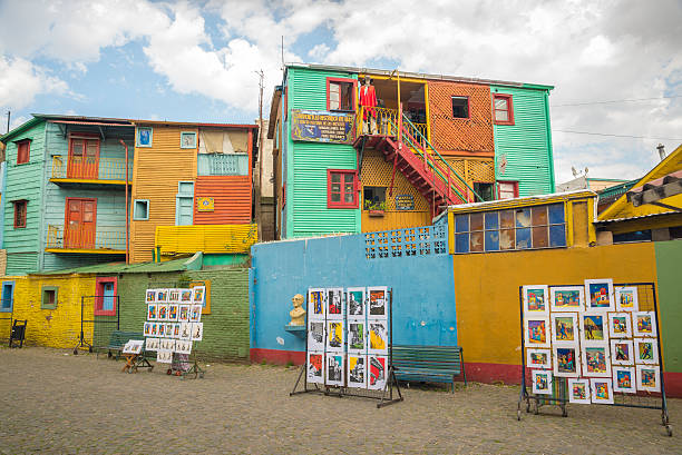 Buenos Aires, Argentina - August 21, 2014: Paintings for sale and the back view of some historical tenement houses besides the ancient Caminito street.