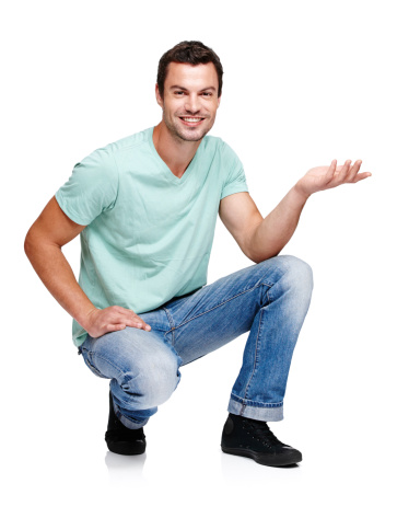 A young man crouching and gesturing towards something while isolated on a white background