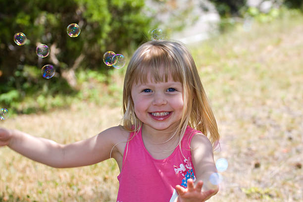 istock Young Girl Playing With Bubbles 509080669