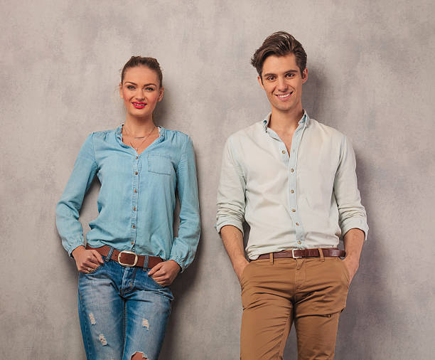 istock smiling couple leaning against the wall with hands in pockets 509090606