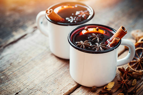 glühwein im weißen rustikalen becher mit gewürzen - glühwein stock-fotos und bilder