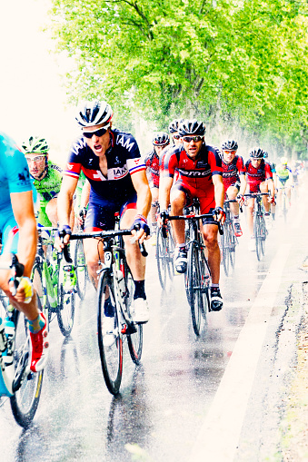 Saint Remy de Provence, France - July 20, 2014: Riders in the Tour de France 2014 entering the town of Saint Remy de Provence in the south of France during a rain storm. The light blue jersey of the rider on the left is on the Astana team from Kazakhstan.