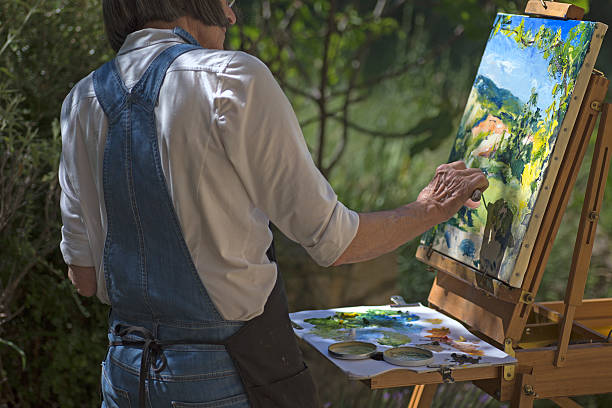 Woman painting outdoors stock photo