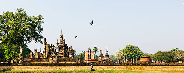 Tourists,  unrecognizable, walk in the ancient temples of Sukhothai