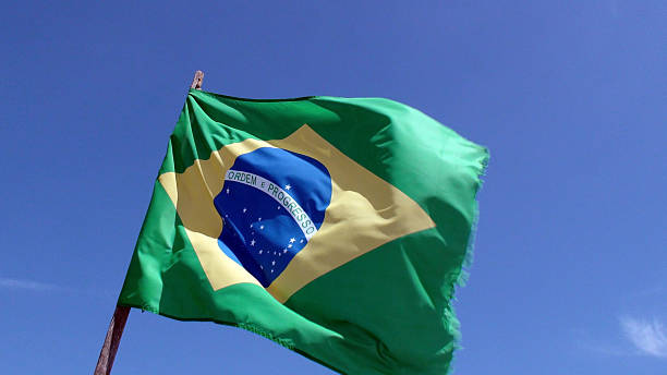 istock Clear Blue Sky And Brazilian Flag Waving 509108152
