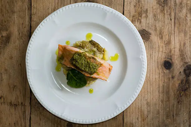 Photo of Salmon fillet, pesto and crushed potato from above