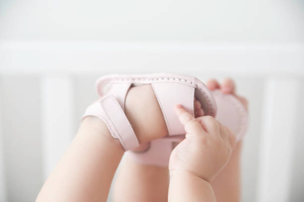 Babies hand touches feet stock photo