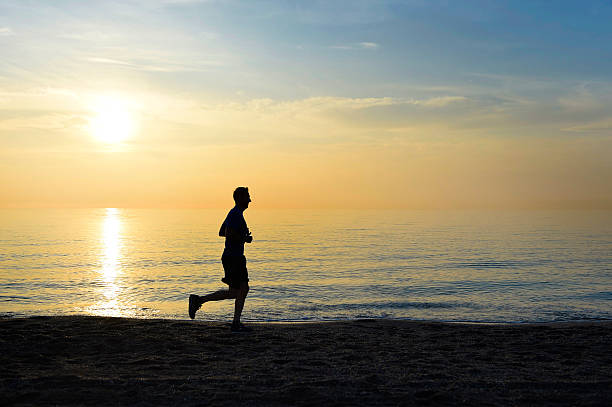 istock silhouette young sport man running on beach sunset orange sky 509115420