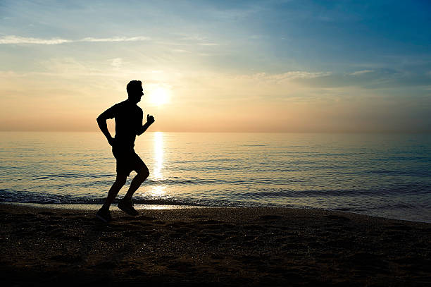 istock silhouette young sport man running on beach sunset orange sky 509116076