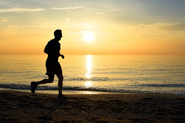 istock silhouette young sport man running on beach sunset orange sky 509116200
