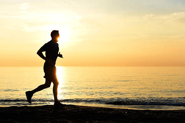 istock silhouette young sport man running on beach sunset orange sky 509116400