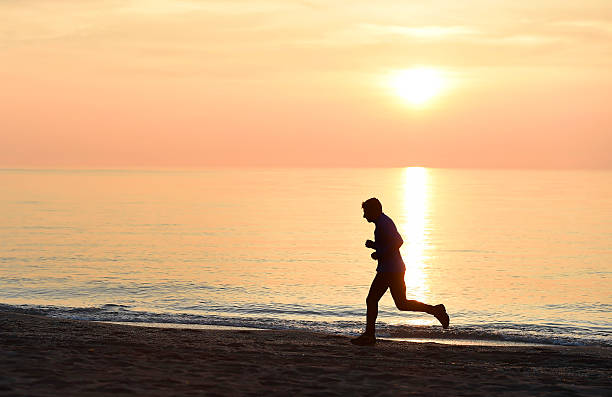 istock silhouette young sport man running on beach sunset orange sky 509117080
