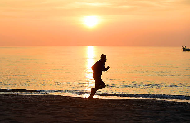 istock silhouette young sport man running on beach sunset orange sky 509117204