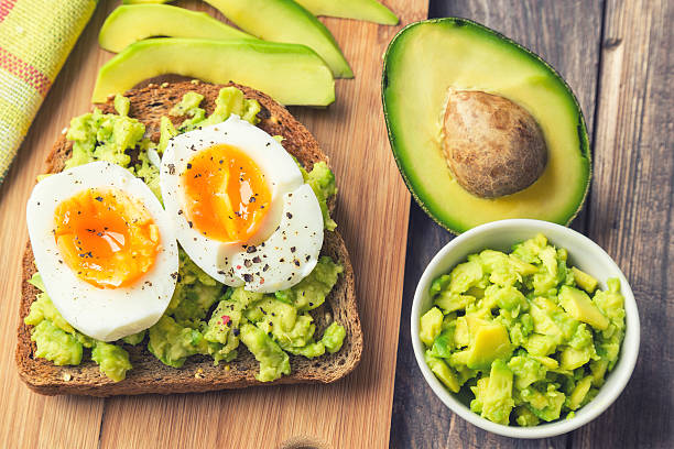 Toast with avocado and egg Toast with avocado and egg on rustic wooden background breakfast sandwhich stock pictures, royalty-free photos & images