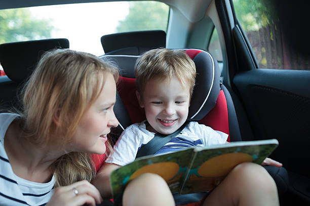 istock Boy holding book sitting in a car with mother 509117267