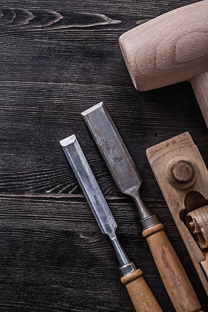 istock Flat chisels wooden hammer planer on wood board construction con 509117996
