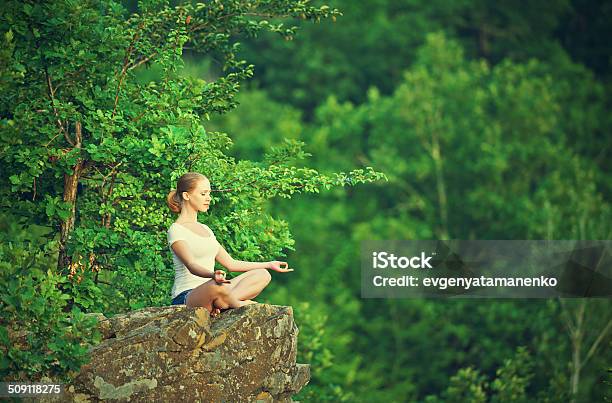 Woman Meditating In Lotus Posture Doing Yoga On Top Stock Photo - Download Image Now
