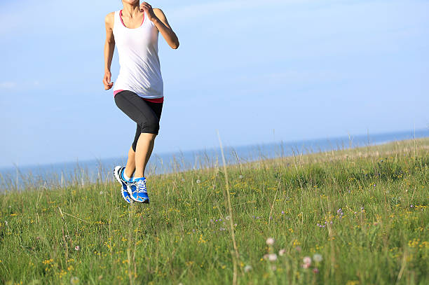 Runner athlete  running on sunrise/sunset grass field. woman fitness jogging workout wellness concept.