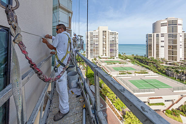 istock Painter Clearing the Cracks on a Highrise Building Being Prepped 509118932