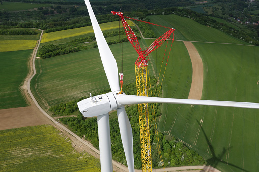 View of wind turbines and agriculture field in blue sky background.