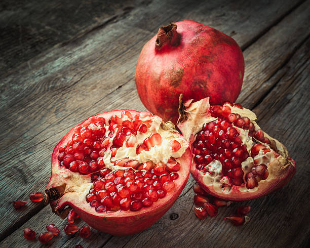 istock Ripe pomegranate slice and whole red garnet fruit on table. 509119766
