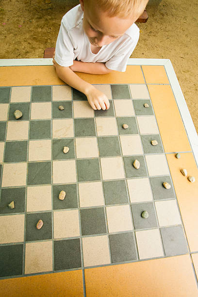 istock Child playing draughts or checkers board game outdoor 509134587