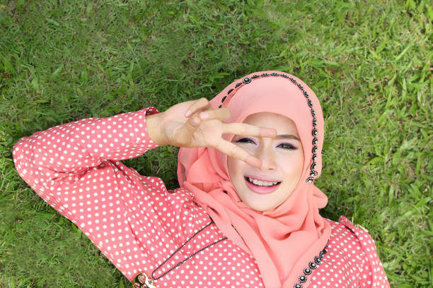 Lovely muslim girl lying on the natural grass