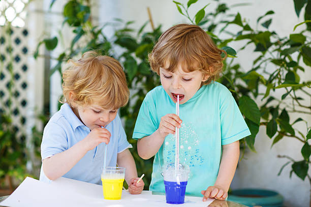 istock Two happy children making experiment with colorful bubbles 509139699