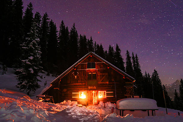 Lightened mountain hut in the austrian alps with milky way Lightened mountain hut in the Austrian alps with milky way. Scenic winter landscape. Night shot with 3200 ISO. chalet stock pictures, royalty-free photos & images