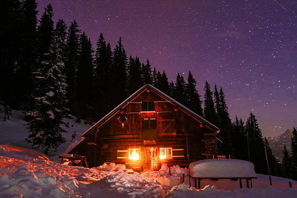 lightened na montanha nos alpes austríacos com o milky way - winter chalet snow residential structure - fotografias e filmes do acervo