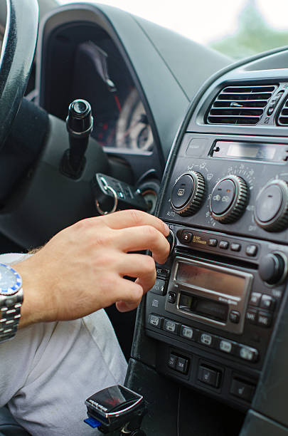 istock Man's hand tuning radio in the car. 509140981