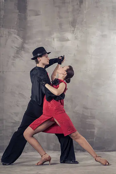Young couple dancing the Argentine tango in the studio