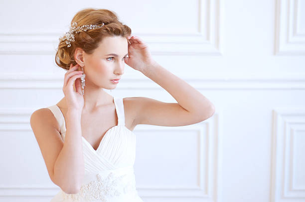 Calm blond bride with blue eyes wearing white gown