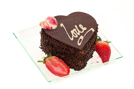 A chocolate Valentines day cake with the word LOVE iced on top - studio shot with a white background