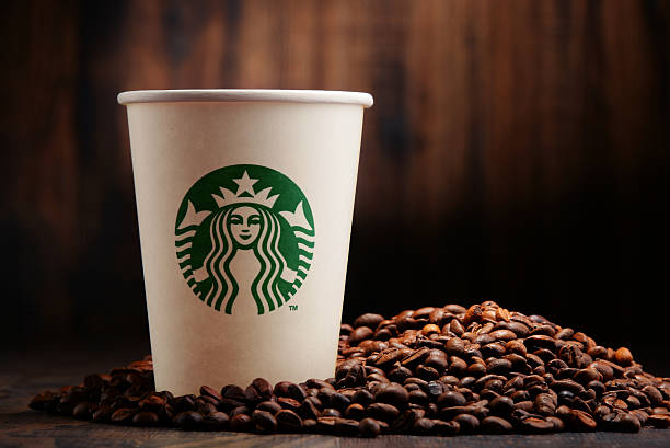 composición con taza de café y granos de café starbucks - starbucks coffee drink coffee cup fotografías e imágenes de stock