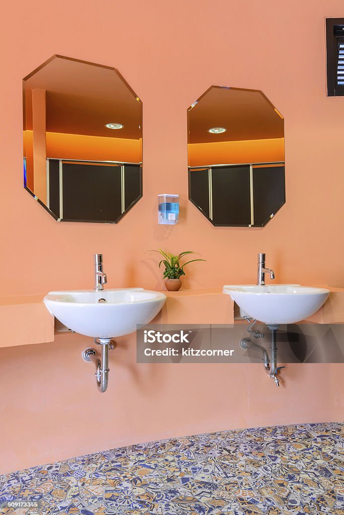 Handbasin and mirror in toilet Handbasin and mirror in bright toilet Apartment Stock Photo
