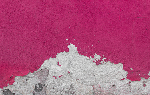 Cracked and textured pink wall, plaster background