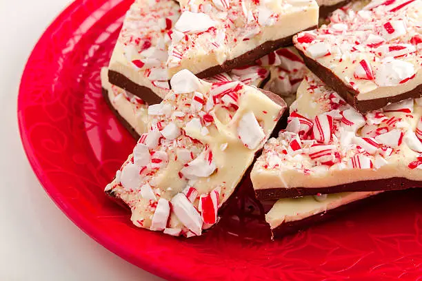 Decorative red plate filled with chocolate peppermint bark candy