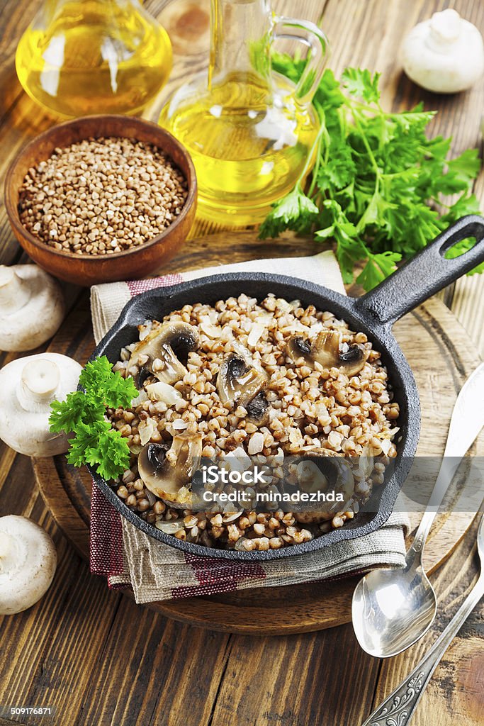 Buckwheat porridge with mushrooms Buckwheat porridge with mushrooms in the frying pan on the table Bread Stock Photo