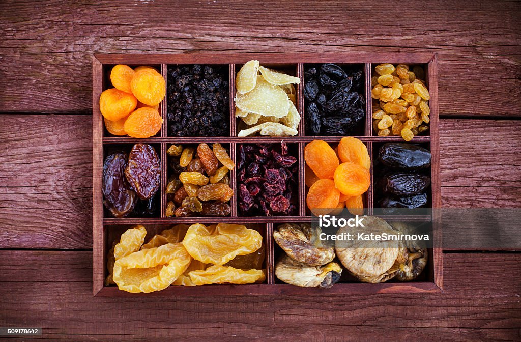 Assorted dried fruits in wooden box Assorted dried fruits in wooden printers box-figs, raisins, date, cranberries, currant, pears, ginger and apricots. Top view. Box - Container Stock Photo