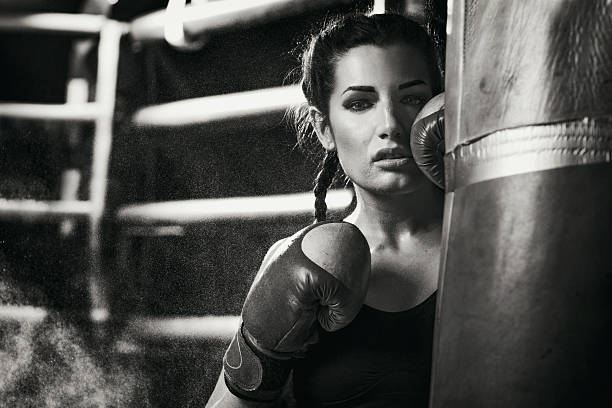 женщина боксер, стоя в боксерская груша - boxing ring фотографии стоковые фото и изображения